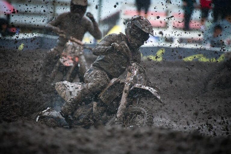 A motocross rider covered in mud.